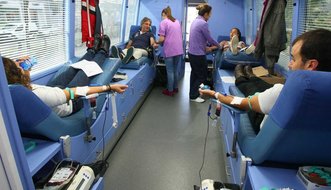 Personas donando sangre en la unidad móvil