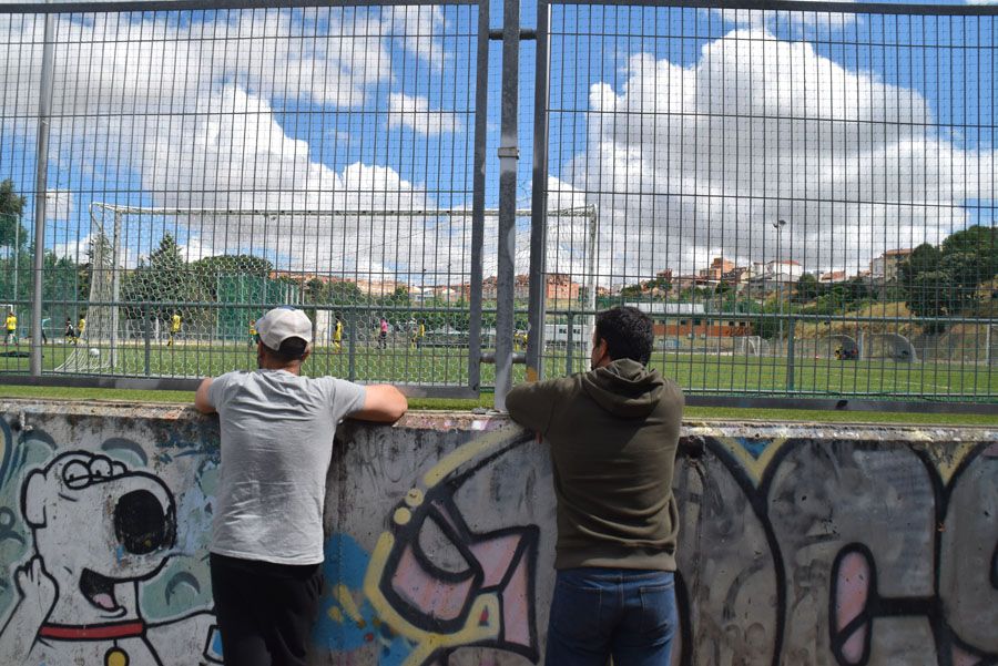 Familiares de jugadores ven el partido desde fuera de la instalación.