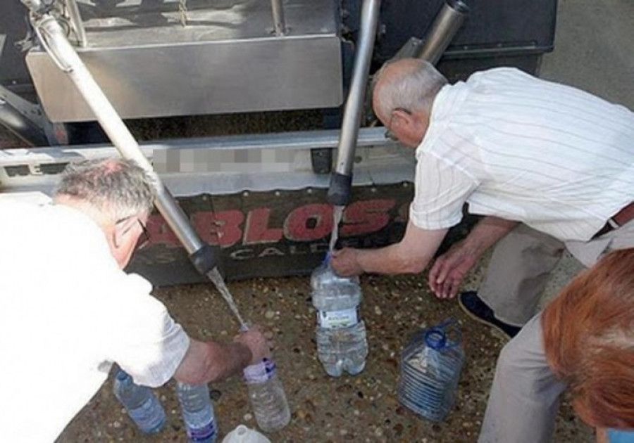 Vecinos abasteciéndose de agua de un camión cisterna