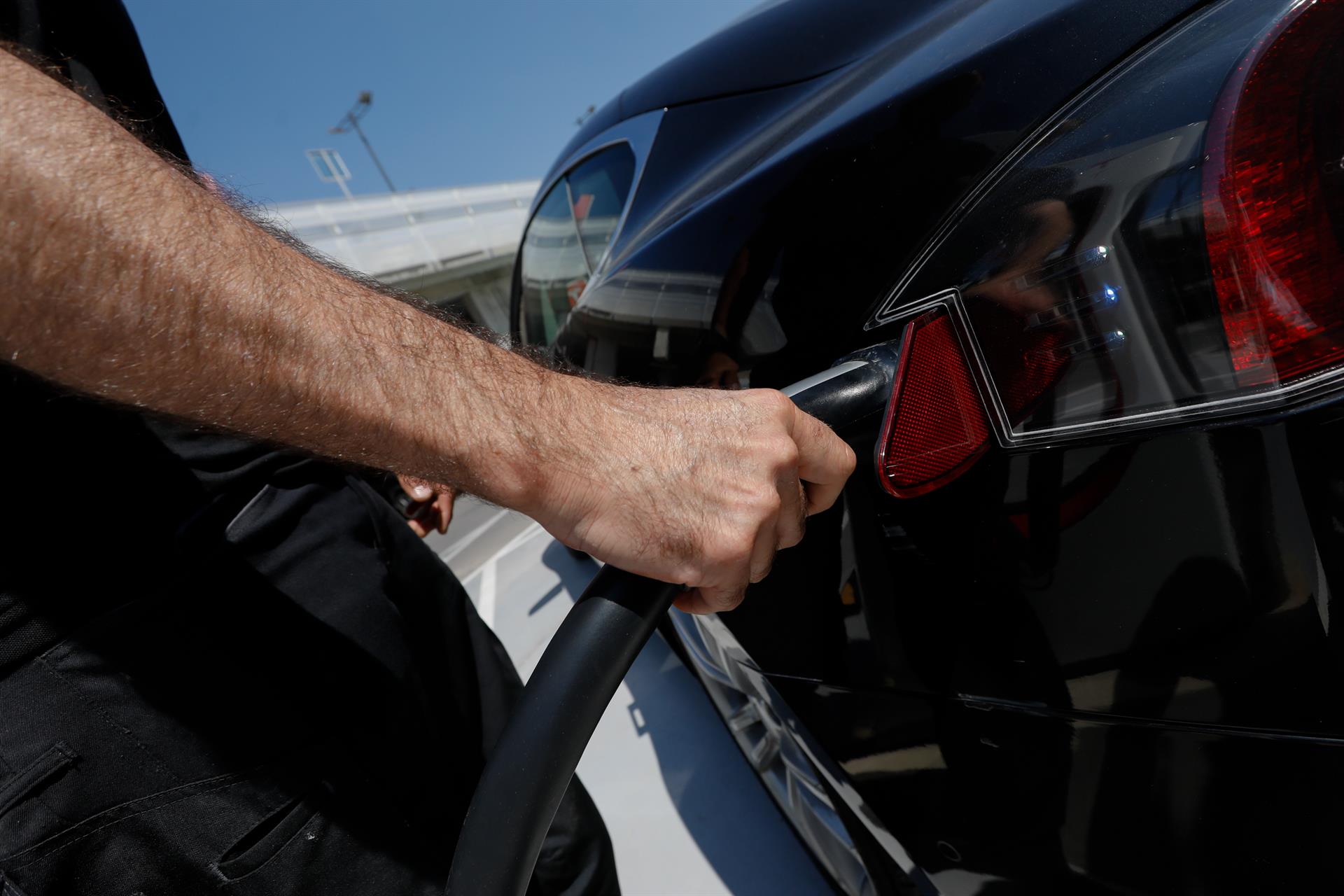 Una persona recarga un coche eléctrico EP