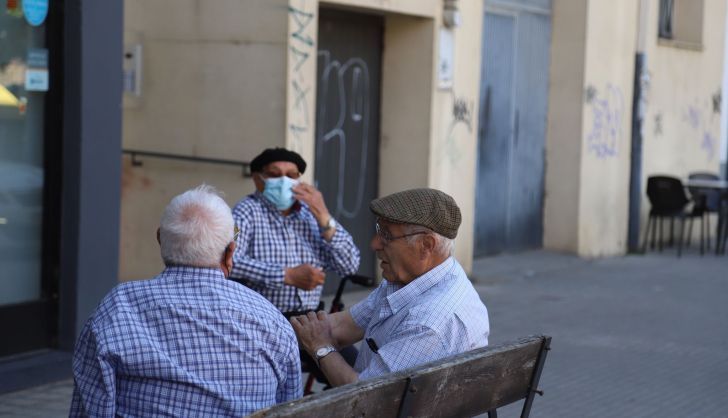 Dos personas mayores conversan sin mascarilla 