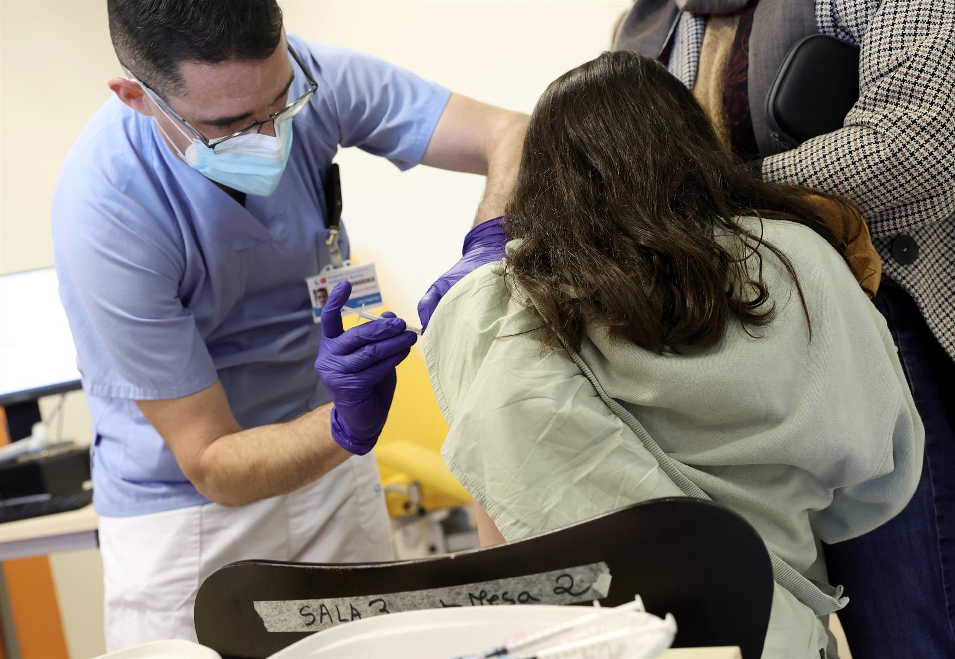 Un trabajador sanitario inyecta la vacuna contra el Covid 19 a un menor