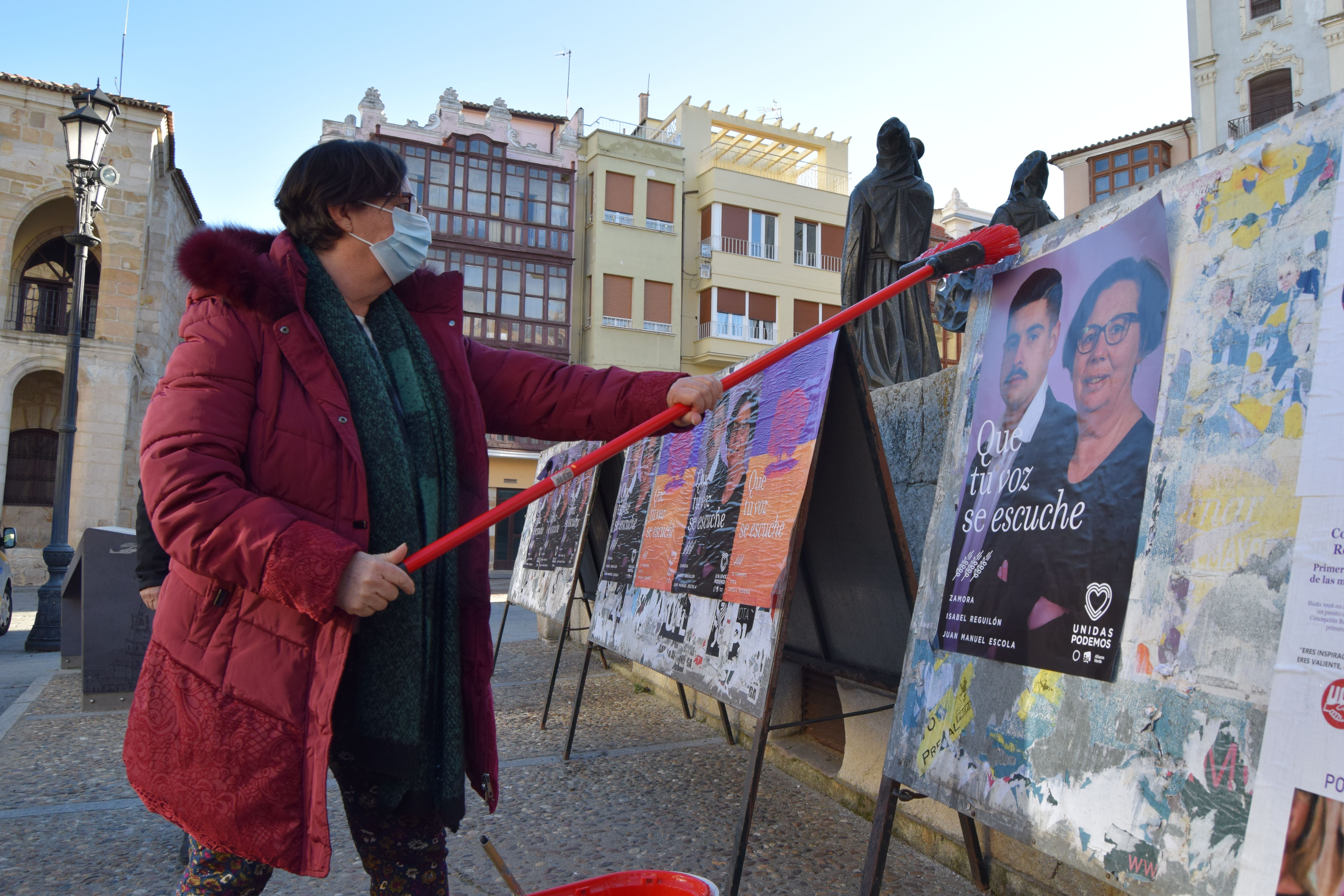 Isabel Reguilón comienza con la pegada de carteles de la campaña del 13-F