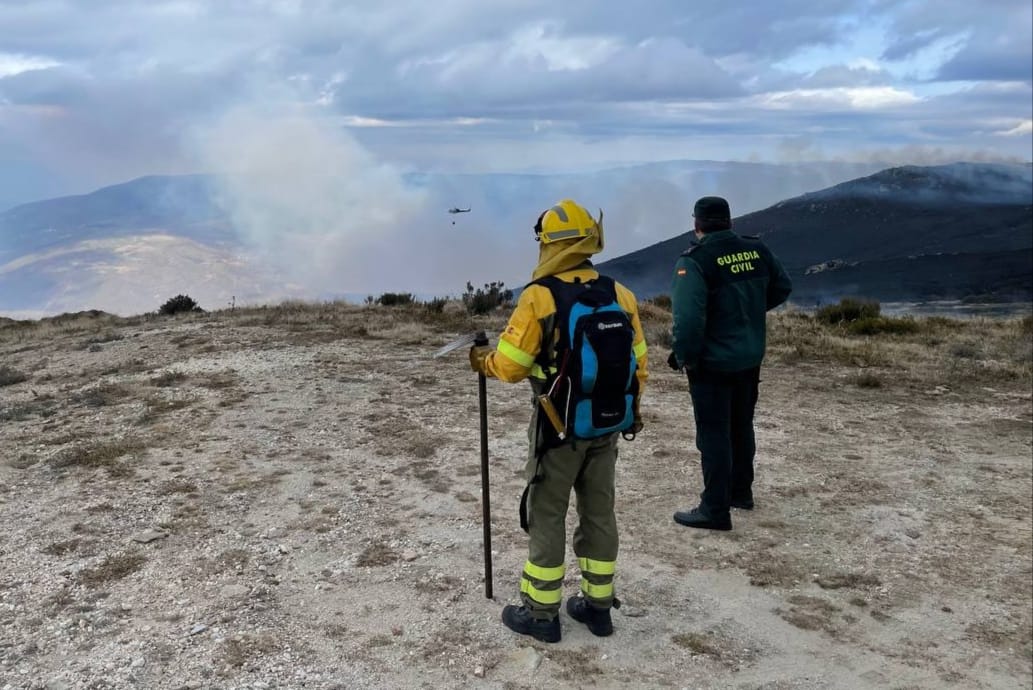 un agente de la guardia civil y un bombero forestal en la zona del incendio