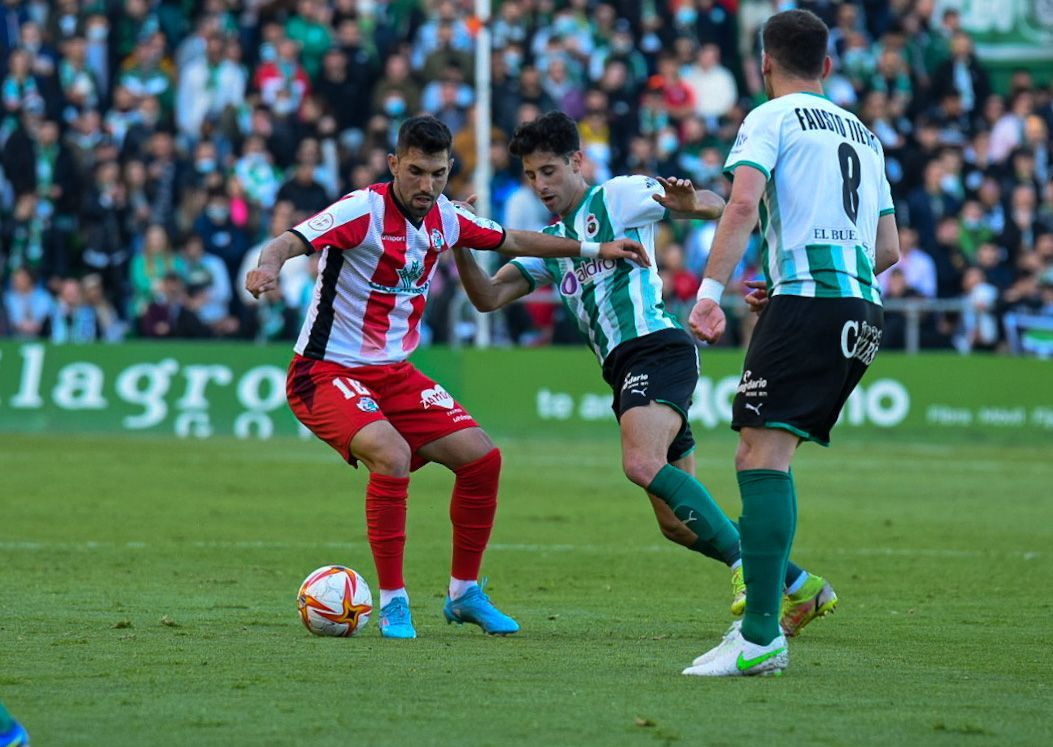 Carlos Ramos intenta proteger la bola ante la presión de dos jugadores del Racing