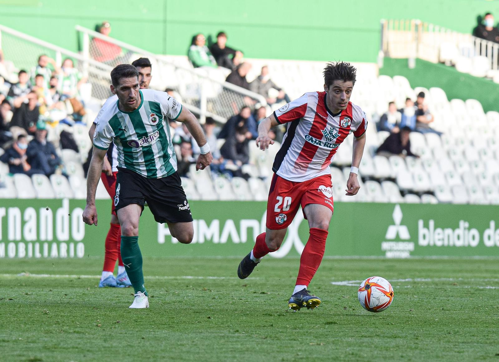 Julián Luque trata de irse de un jugador del Racing de Santander