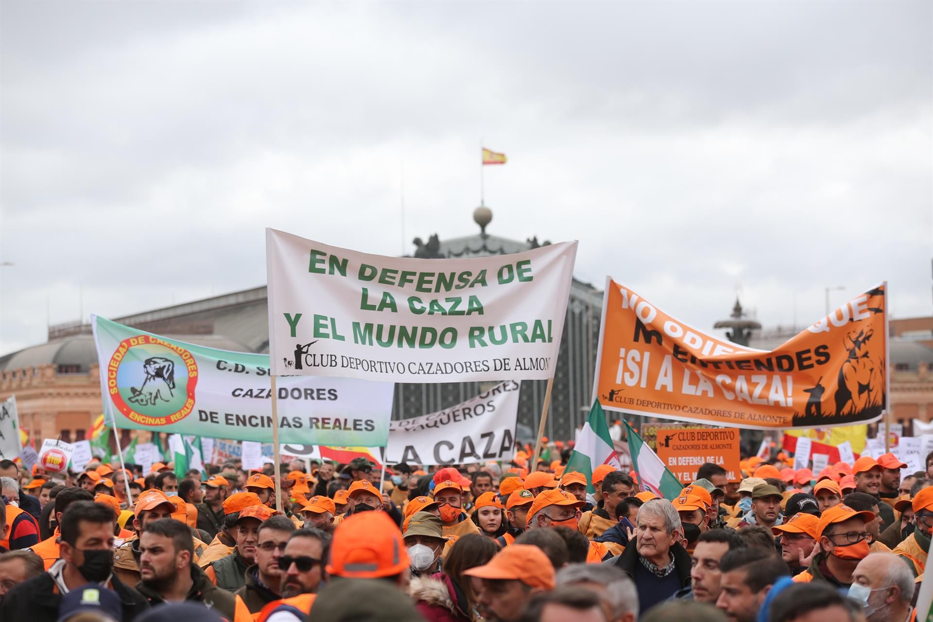 Varios manifestantes, con gorras naranjas y pancartas en defensa de la caza, en la marcha ‘20M’