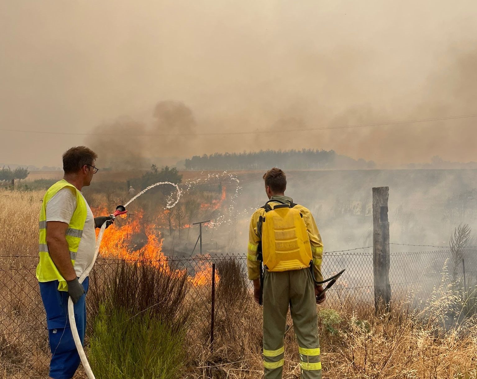 Imagen de un vecino junto a un bombero forestal en el entorno del incendio de Losacio. Archivo.