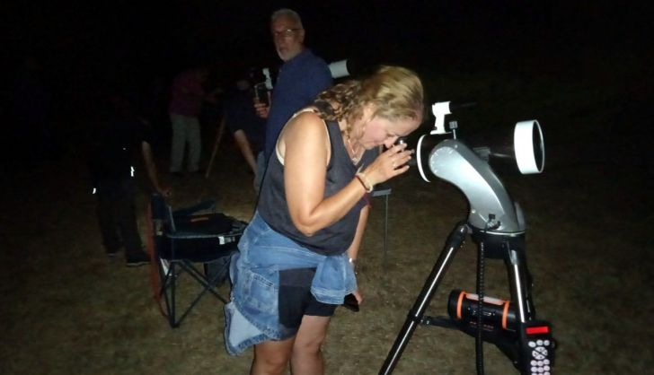 Una mujer observa a través de un telescopio