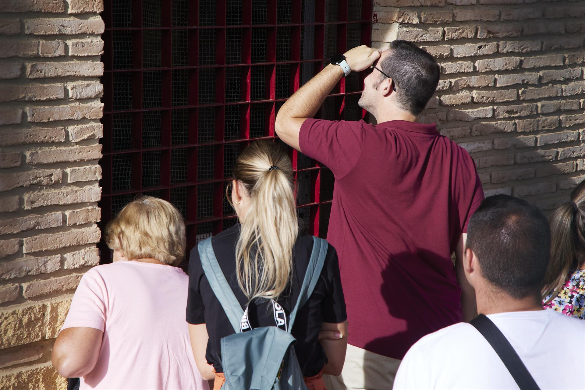 Unos padres asomados a la ventana para observar a sus hijos en el día de la inauguración del curso