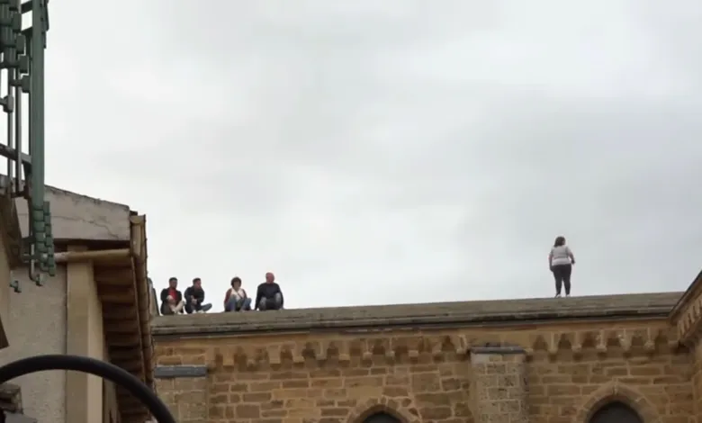 Personas ven el Toro Enmaromado desde el tejado de la iglesia de Santa María del Azogue