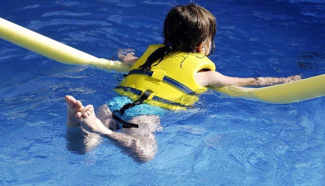 Una niña bañándose en una piscina. Foto Infosalus