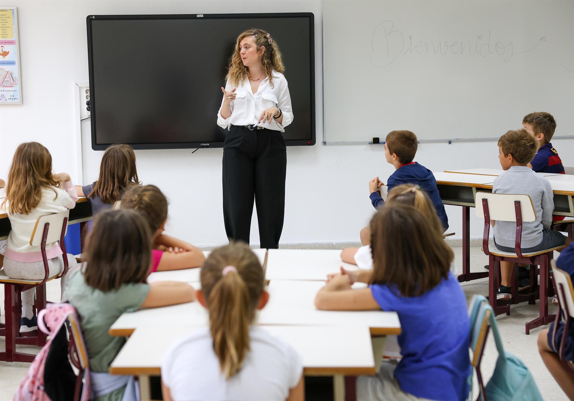 Una profesora y varios alumnos en un colegios. EP. Archivo.