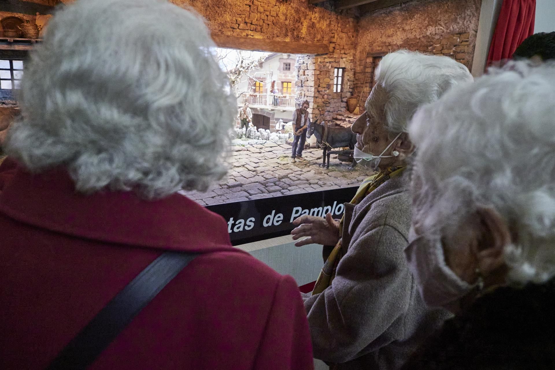 Varias señoras mayores viendo un belén-Archivo 