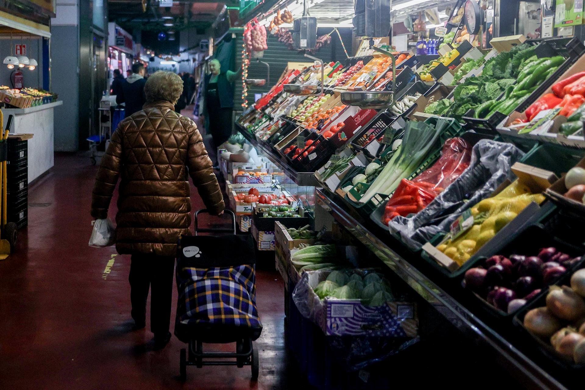 Una mujer realiza sus últimas compras antes de la cena de Nochebuena, en el Mercado de la Cebada. EP