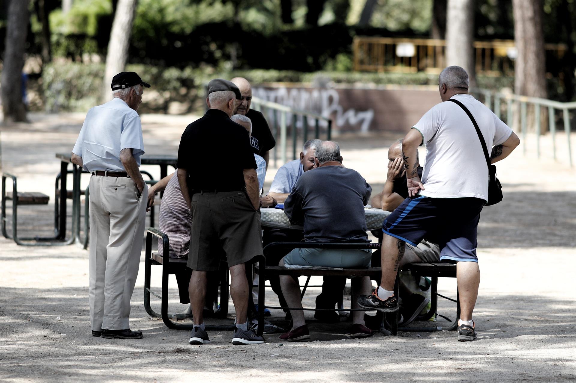 Varios pensionistas juegan al dominó en un parque. Archivo.