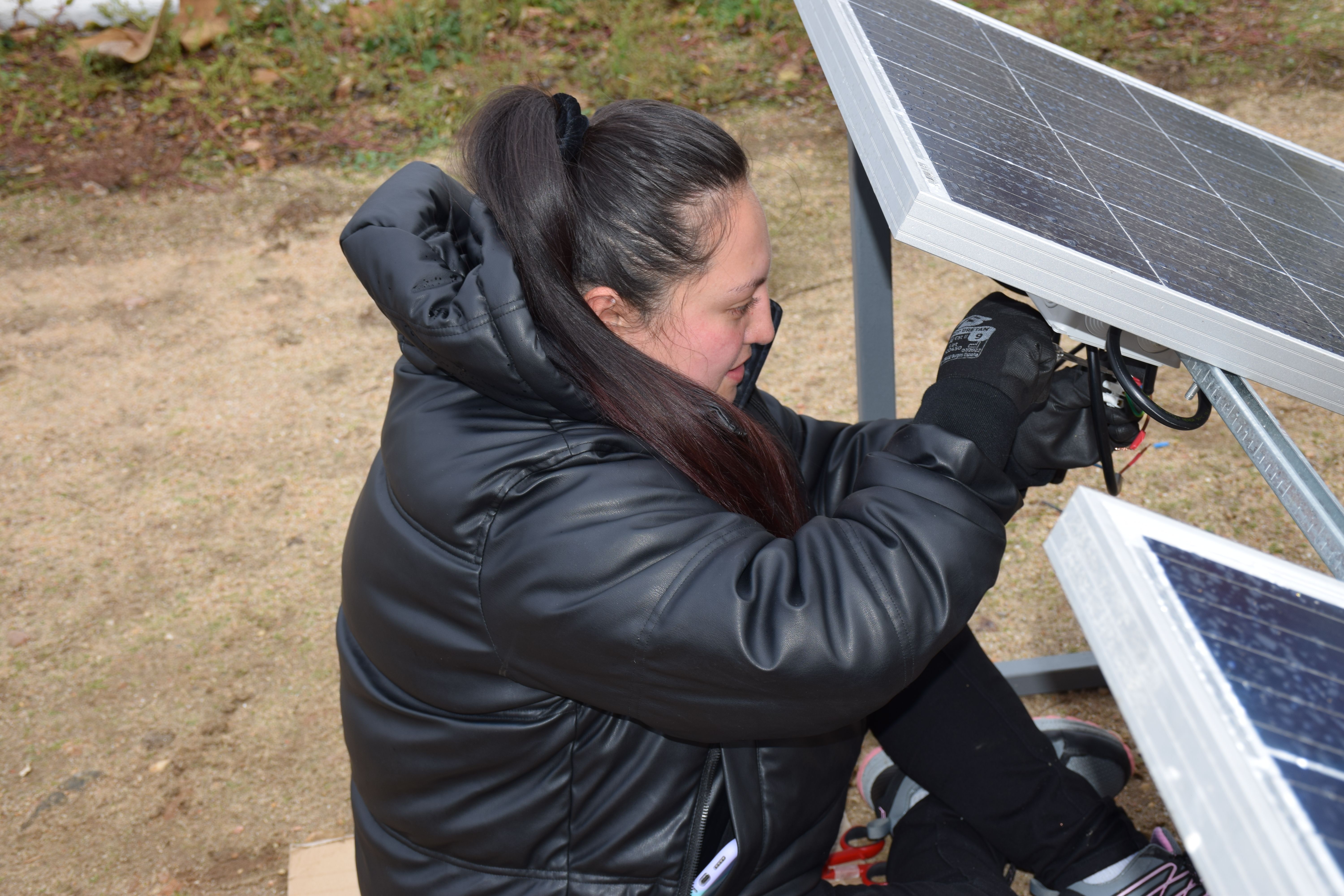 Una alumna realizando una intervención a una placa solar.