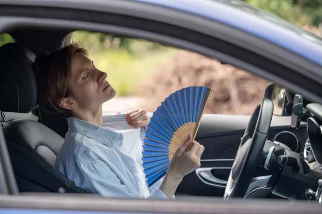 Una mujer se abanica en el coche por el calor. Foto: Infosalus. Archivo.