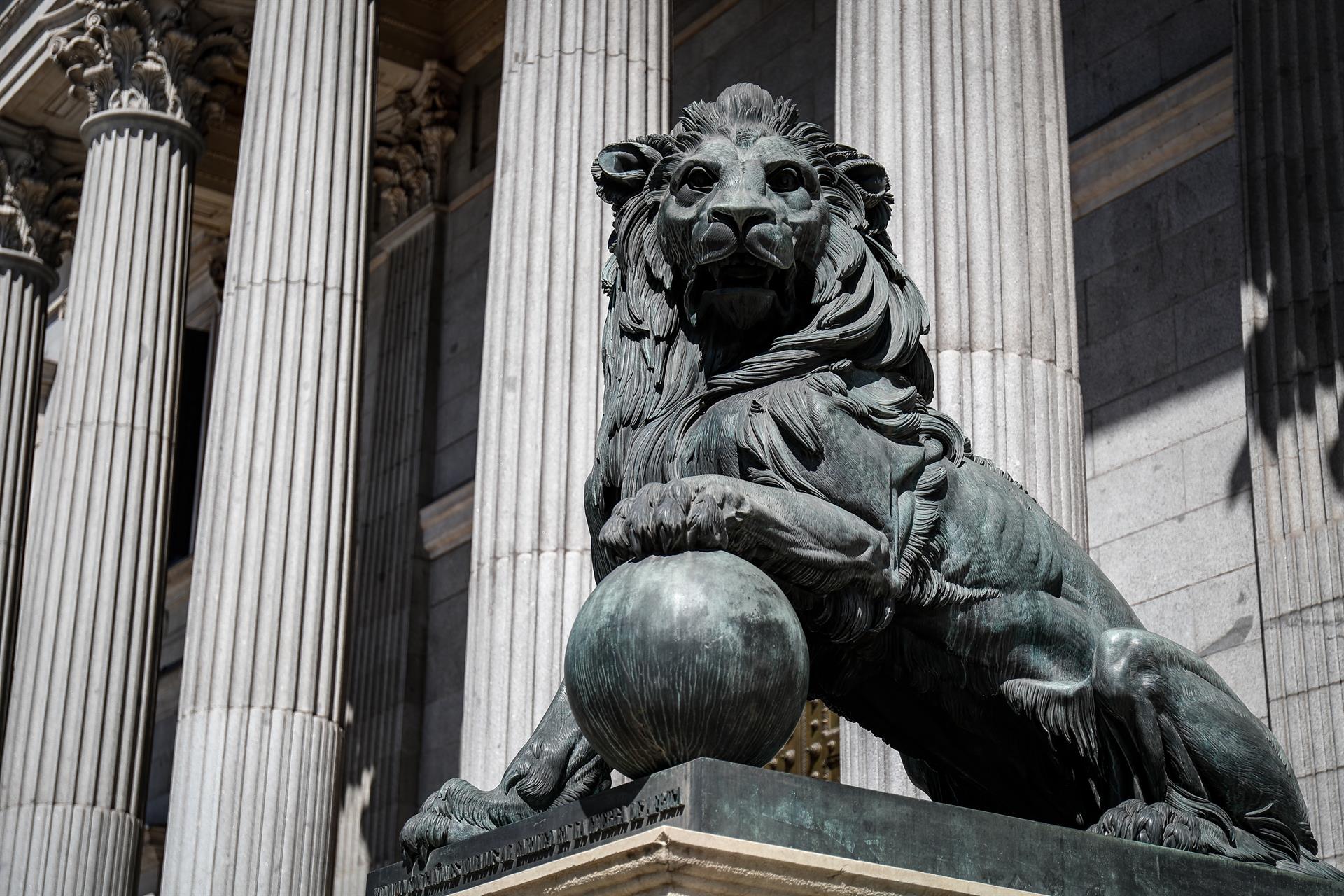 Uno de los emblemáticos leones que se encuentran delante de la fachada del Congreso de los Diputados en la Plaza de las Cortes de Madrid. - Óscar J.Barroso - Europa Press - Archivo