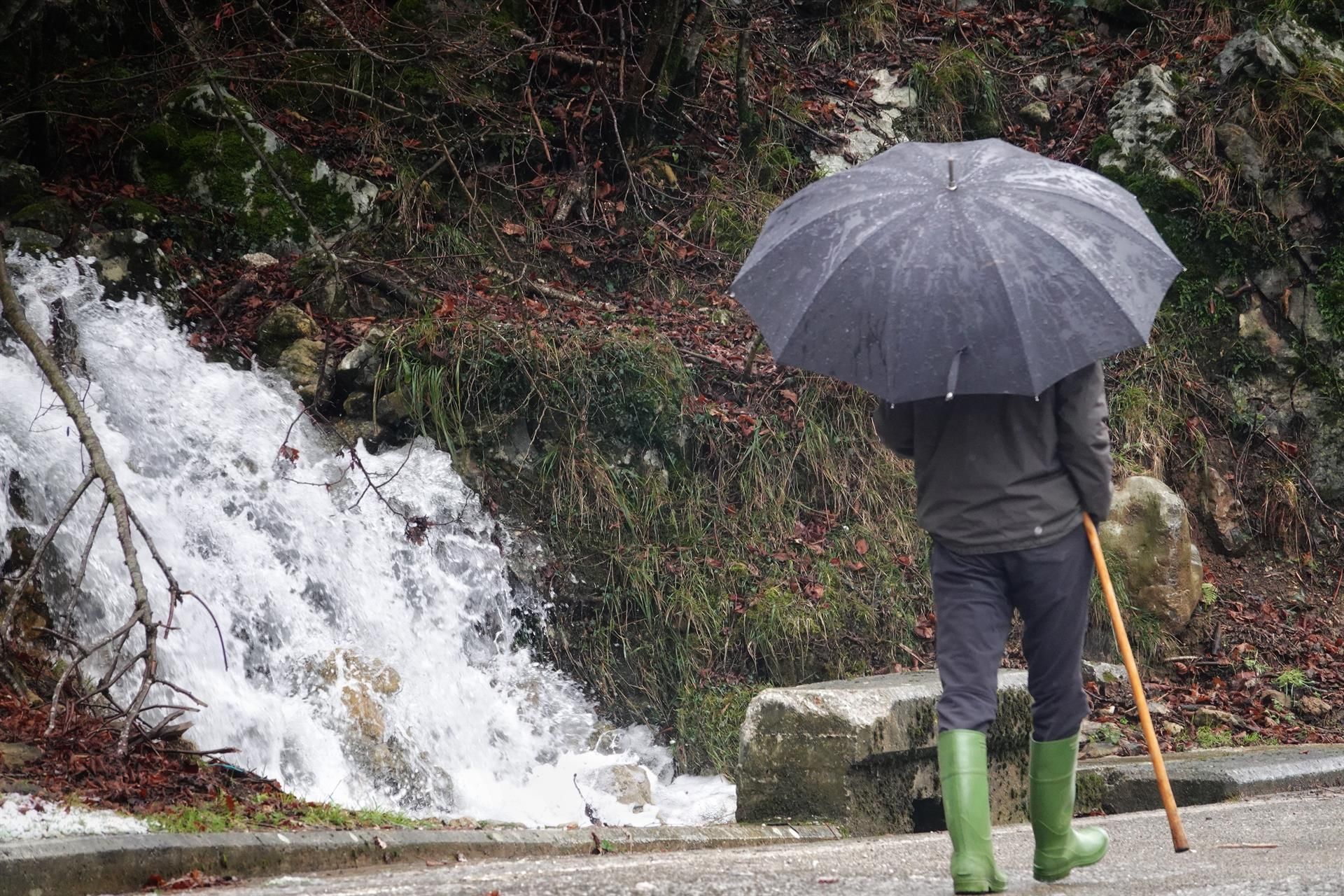 Un hombre pasea con paraguas por la aldea de Tielve, a 17 de enero de 2023, en Tielve, Cabrales, Asturias (España). - Xuan Cueto - Europa Press - Archivo