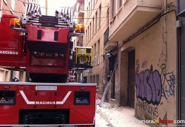  Los Bomberos actúan en la calle San Miguel tras desprenderse el revestimiento de una fachada 