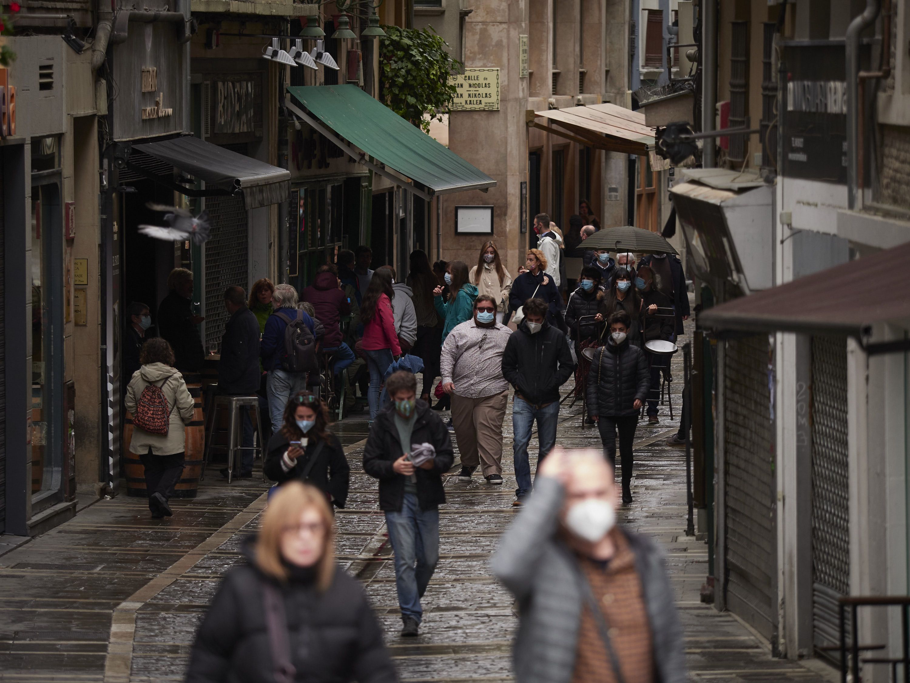 Transeúntes pasean por una calle protegidos con mascarilla debido a la crisis sanitaria del Covid-19. EP