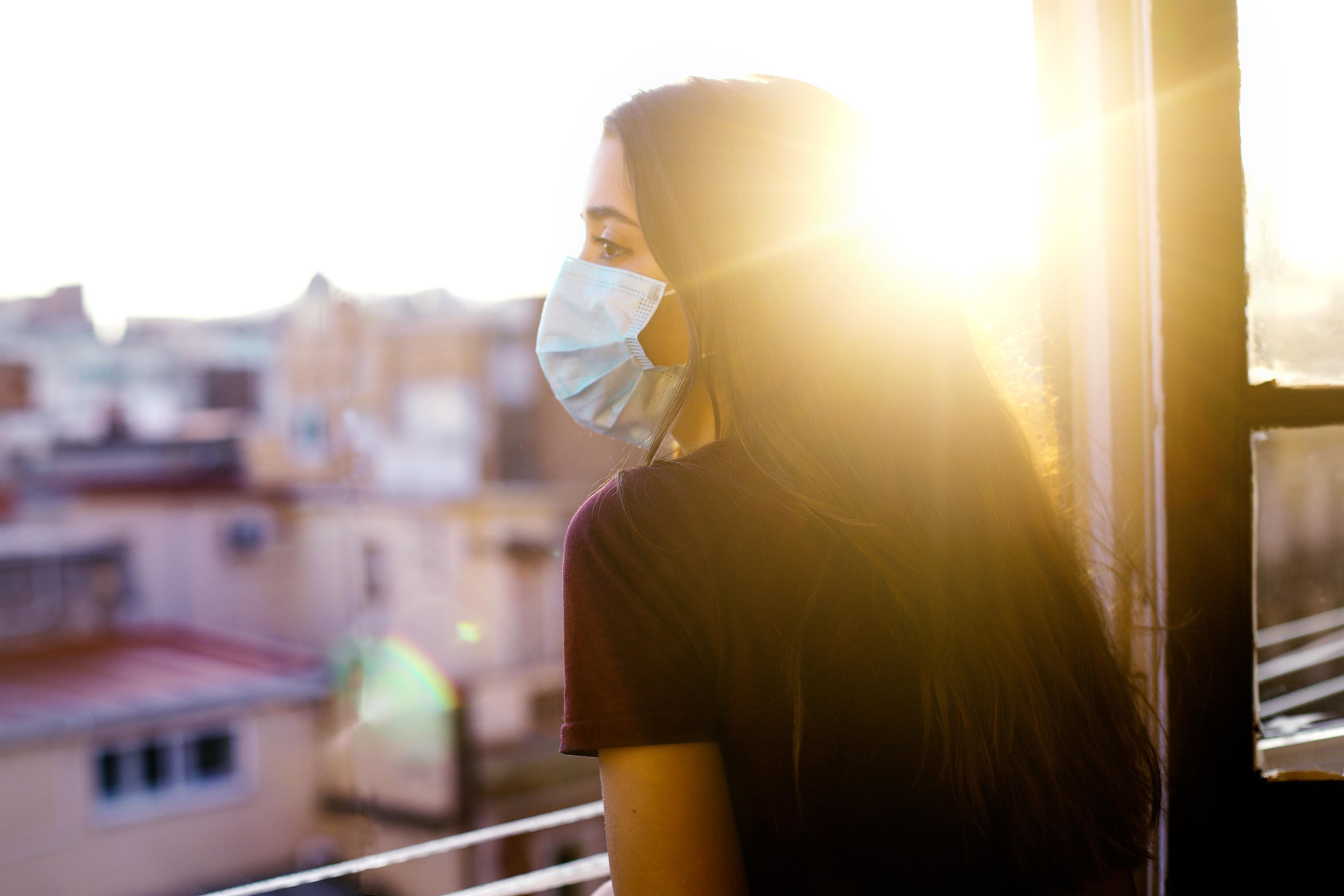  Una joven asomándose a la ventana de su vivienda (Archivo) 