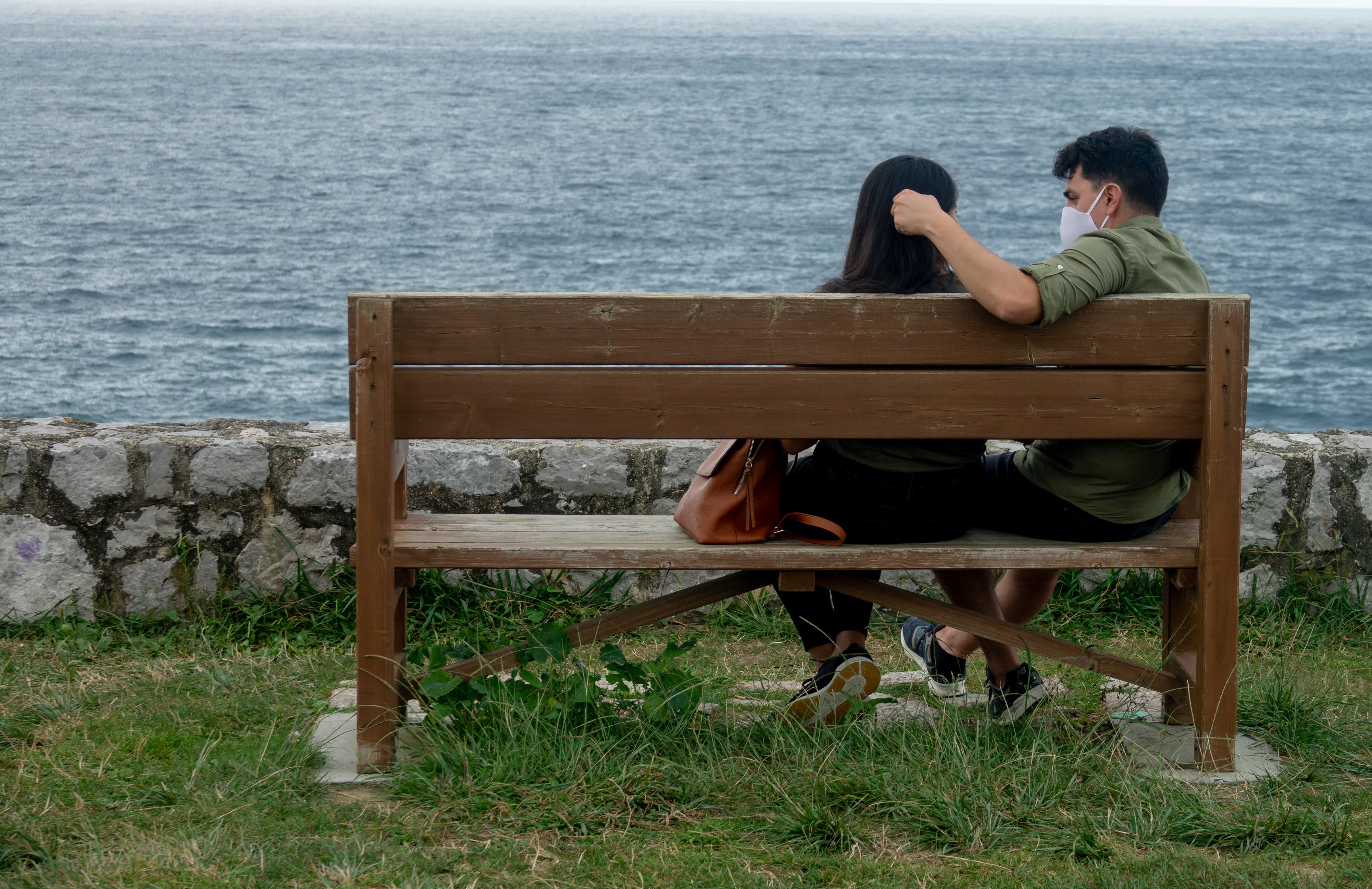  Una pareja sentada con mascarillas en LLanes, Asturias. 